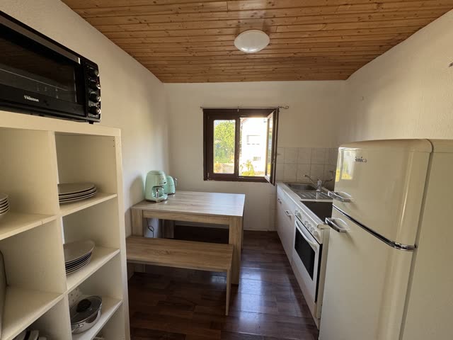 Küche mit Küchenzeile, Essplatz und Holzdecke